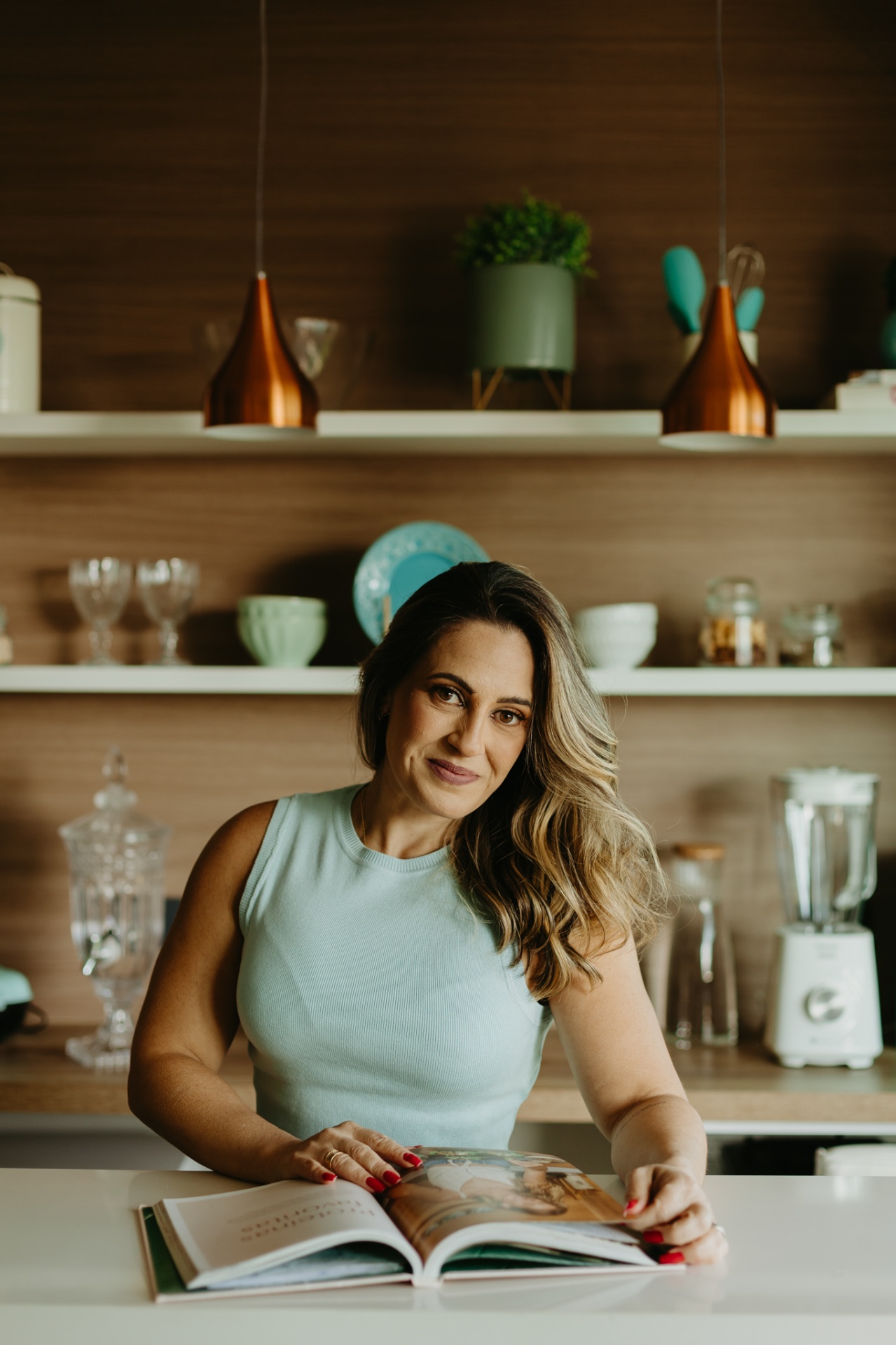 Fabiana Moreira folheando livro de receitas em ambiente acolhedor